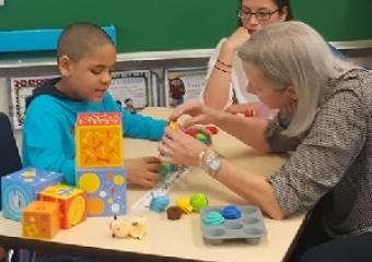 一位母亲在护理技能培训讲习班上与自闭症儿童一起工作。图片由Mom2Mom提供