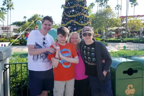 Kim McKafferty和她的丈夫和儿子在迪斯尼乐园，背景是一棵圣诞树。