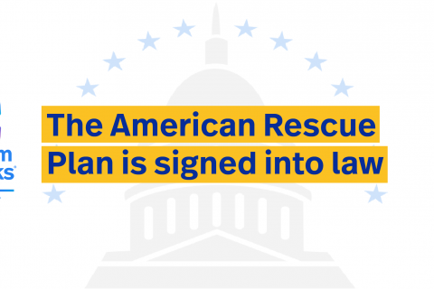 “美国救援计划被签署成为法律”的文字写在褪色的国会大厦圆顶上